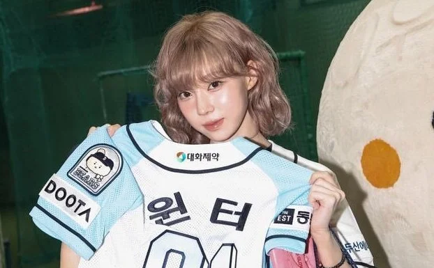 K-pop star Winter of the group aespa stole the show at a baseball game by throwing out the first pitch. She donned a Doosan Bears uniform and impressed fans with her cute appearance.