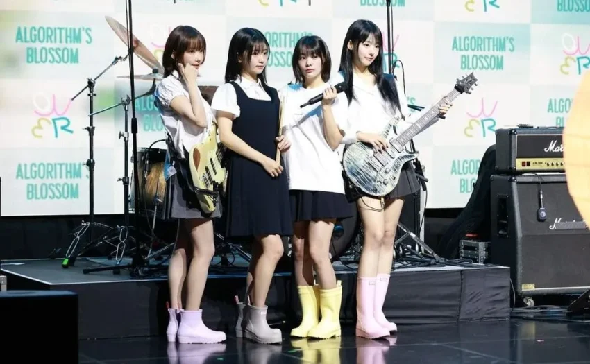 QWER achieved significant success on domestic charts with their latest release, Algorithm's Blossom, particularly with the title track My Name is Malguem. Despite their chart achievements, some people debate the band's background as former streamers and question their skills.